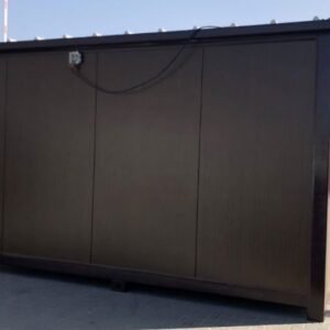 Außenansicht des Saunacontainers 4,00 x 2,20 m in Dunkelbraun mit Anschlusskasten, auf Pflasterfläche