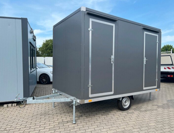 Anthrazitfarbener WC-Anhänger Damen/Herren mit Toilette schräg von vorn, zwei Türen und Deichsel